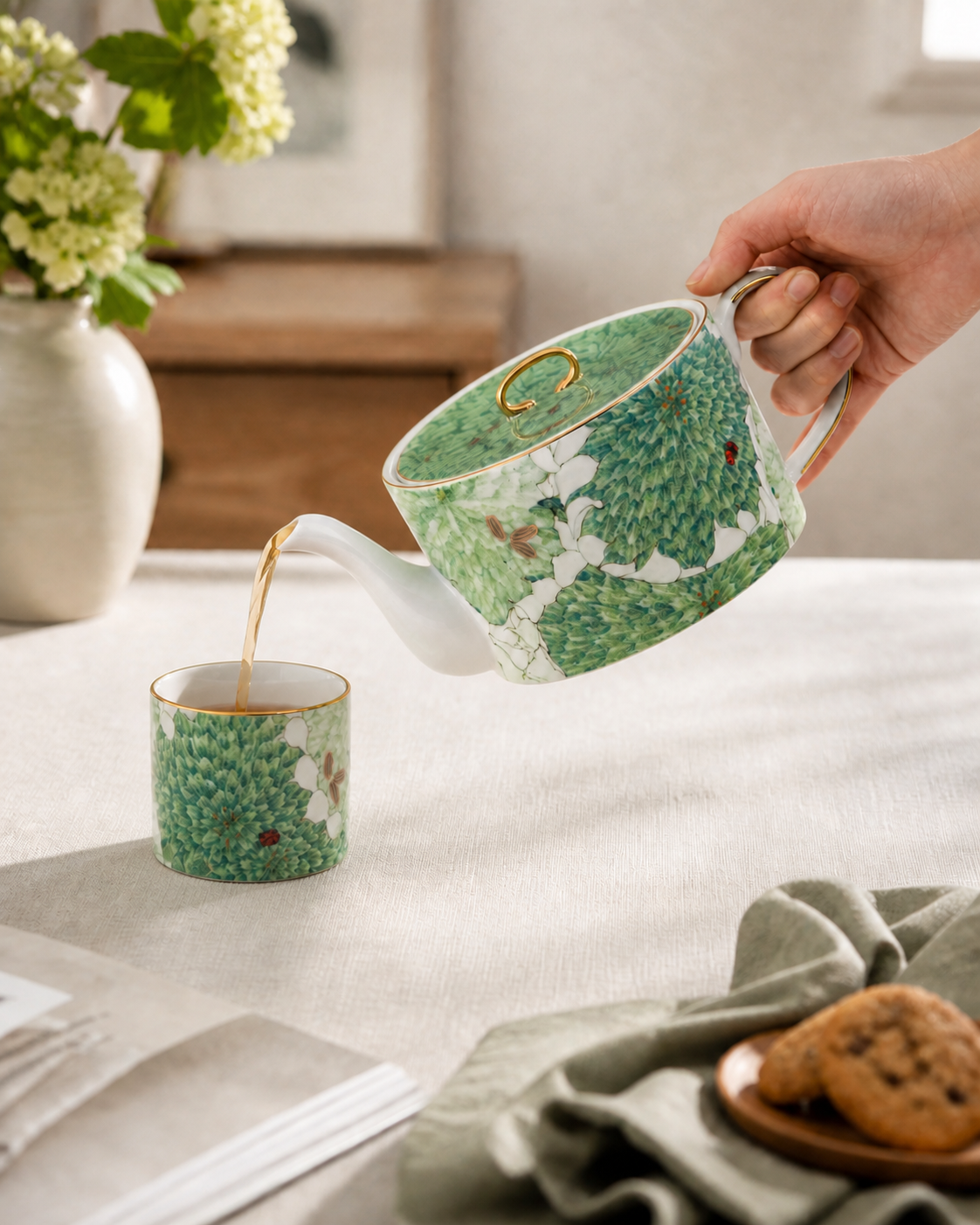 A hand pouring tea from the 500 ml teapot into a correctly scaled 7.2 cm matching cup