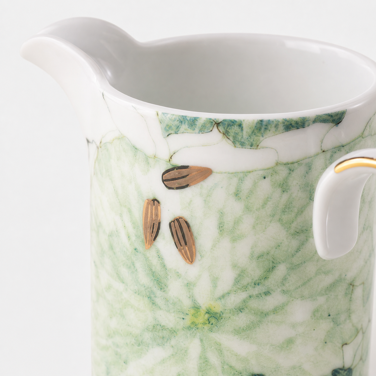 Close-up of Chasing Light creamer spout, flat botanical decal and restrained gold detail