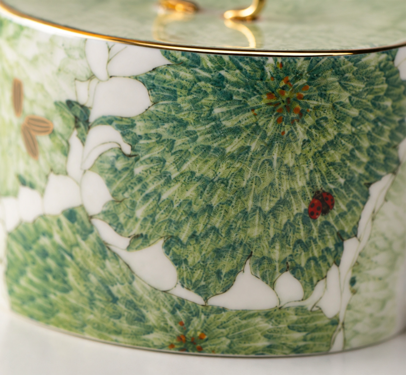 Close detail of the Chasing Light teapot flat botanical decal, glaze and fine gold-toned outline